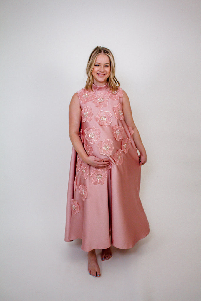 blush pink A-line gown with intricate floral embellishments and a high neckline