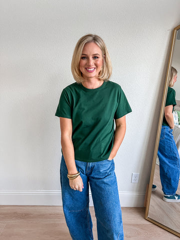 Forest green tee shirt with a classic crew neckline, short sleeves, and a relaxed fit, perfect for casual or layered looks, styled for a chic boutique vibe.