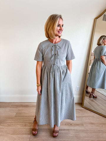 Striped midi dress with a flattering bow-tie front detail, short sleeves, and a flowy, gathered skirt. A timeless boutique piece perfect for a chic and comfortable look