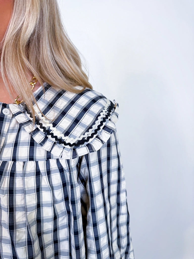 Woman wearing Autumn Stroll Dress in white with black and mustard with dark green, styled for fall