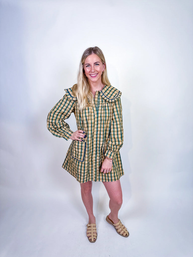 Woman wearing Autumn Stroll Dress in white with black and mustard with dark green, styled for fall