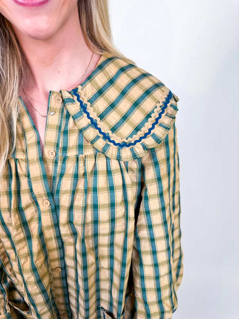 Woman wearing Autumn Stroll Dress in white with black and mustard with dark green, styled for fall