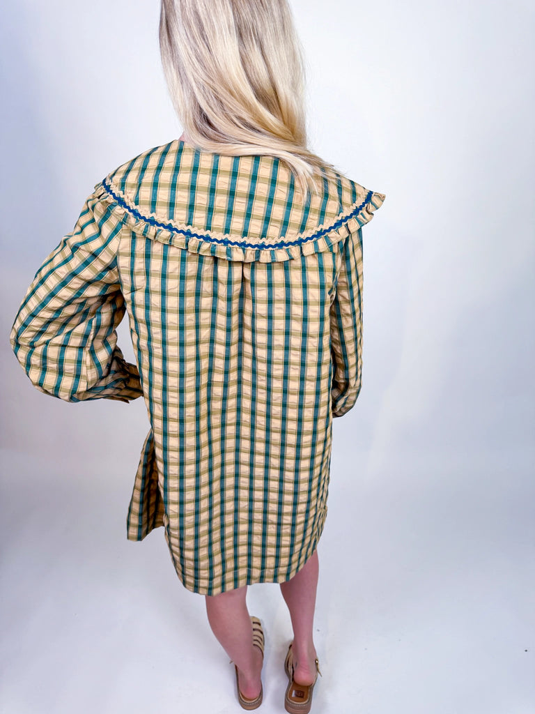 Woman wearing Autumn Stroll Dress in white with black and mustard with dark green, styled for fall