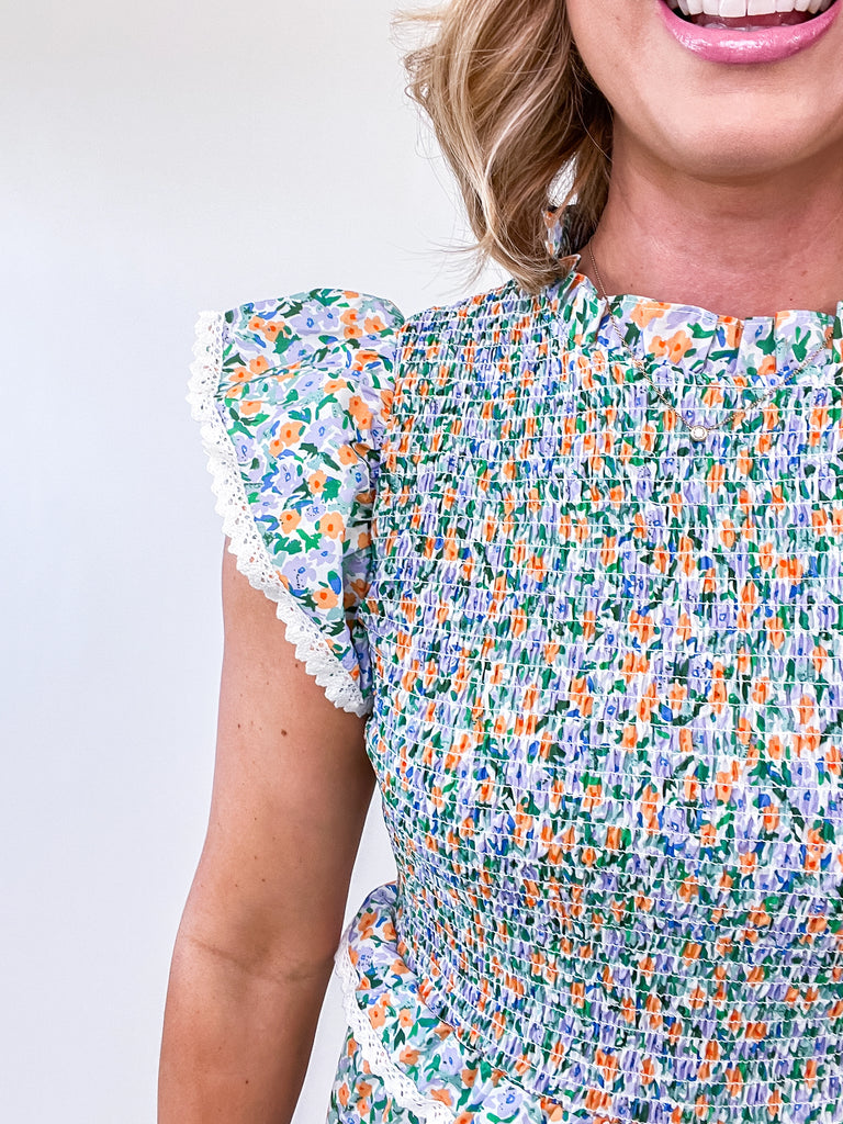 Pastel floral smocked midi dress with flutter sleeves and lace trim