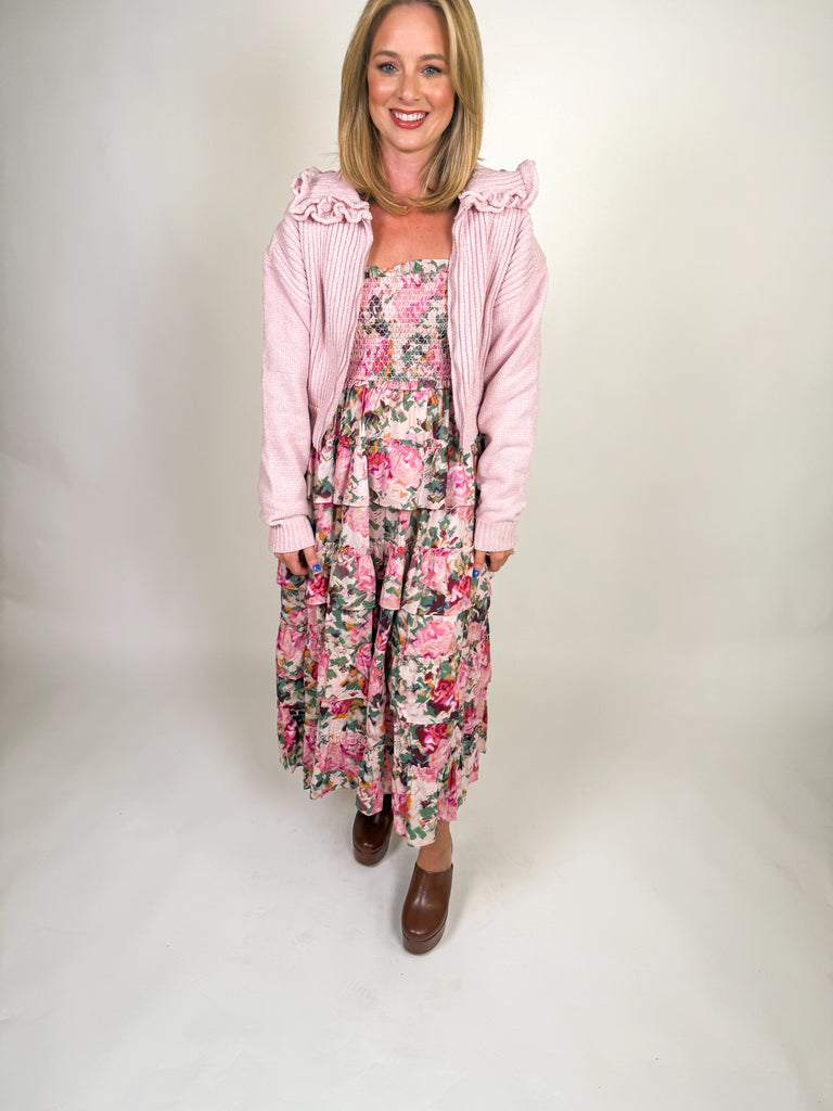Woman wearing blush pink ruffle zip jacket with ribbed knit texture and feminine collar detail