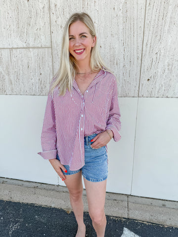 Woman wearing a red and white striped oversized button-down shirt