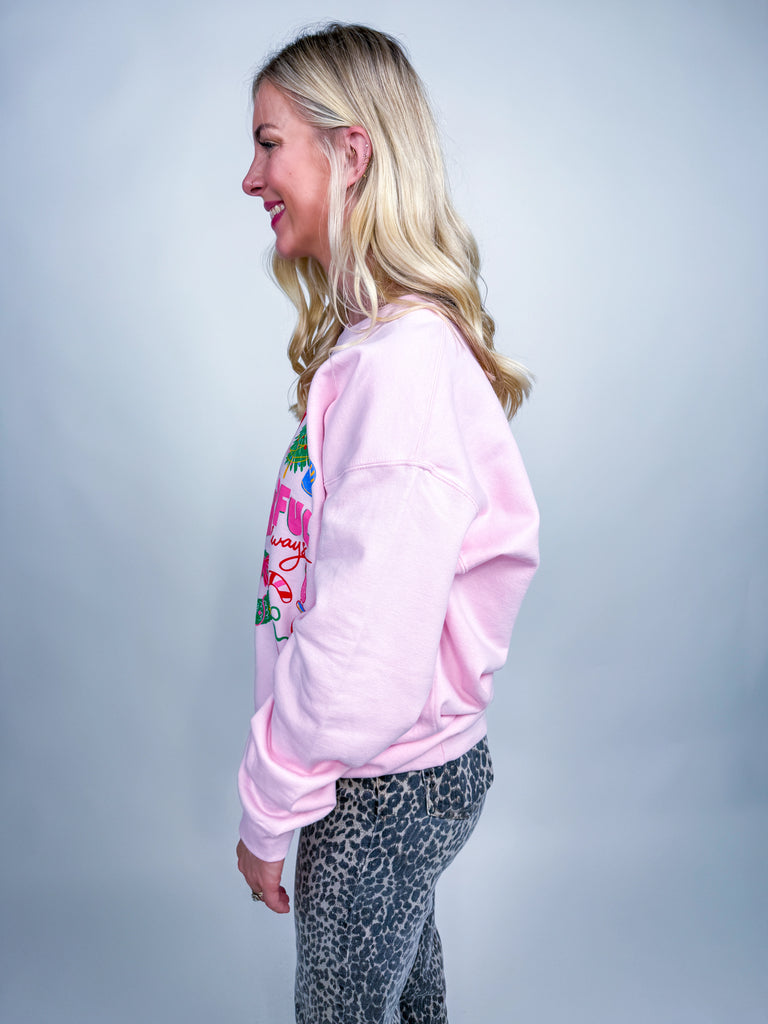 Woman wearing pink Cheerful Always sweatshirt with festive Christmas icons and lettering