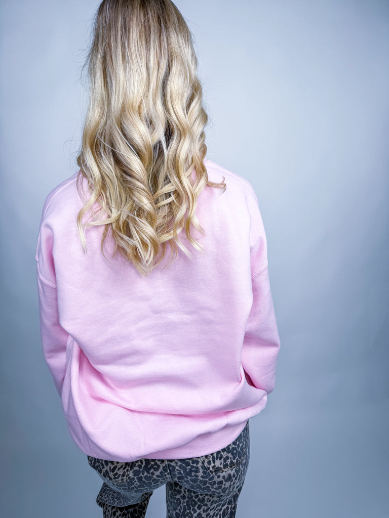 Woman wearing pink Cheerful Always sweatshirt with festive Christmas icons and lettering