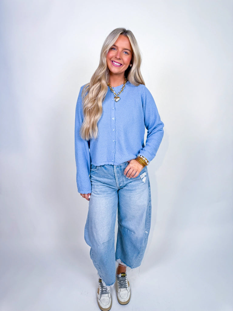 Woman wearing textured knit button-front cardigan in butter yellow and cornflower blue