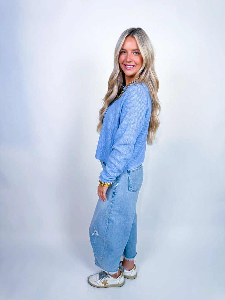 Woman wearing textured knit button-front cardigan in butter yellow and cornflower blue