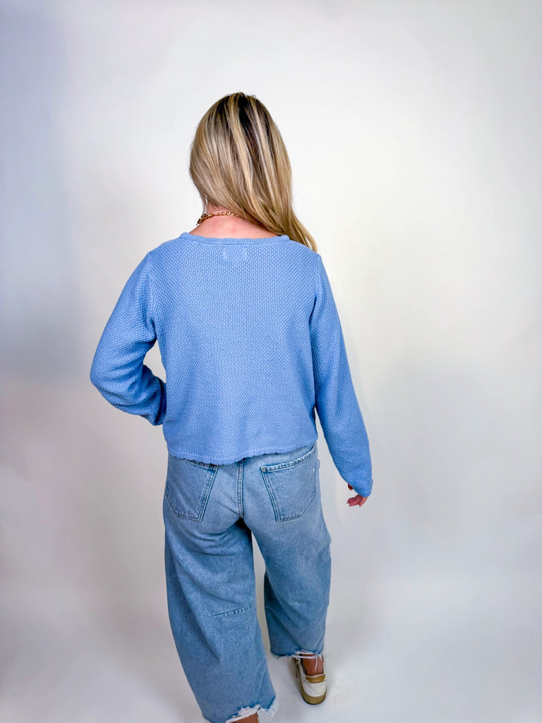 Woman wearing textured knit button-front cardigan in butter yellow and cornflower blue