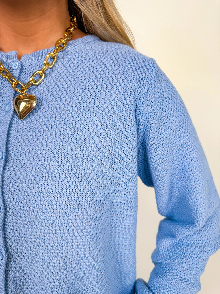 Woman wearing textured knit button-front cardigan in butter yellow and cornflower blue