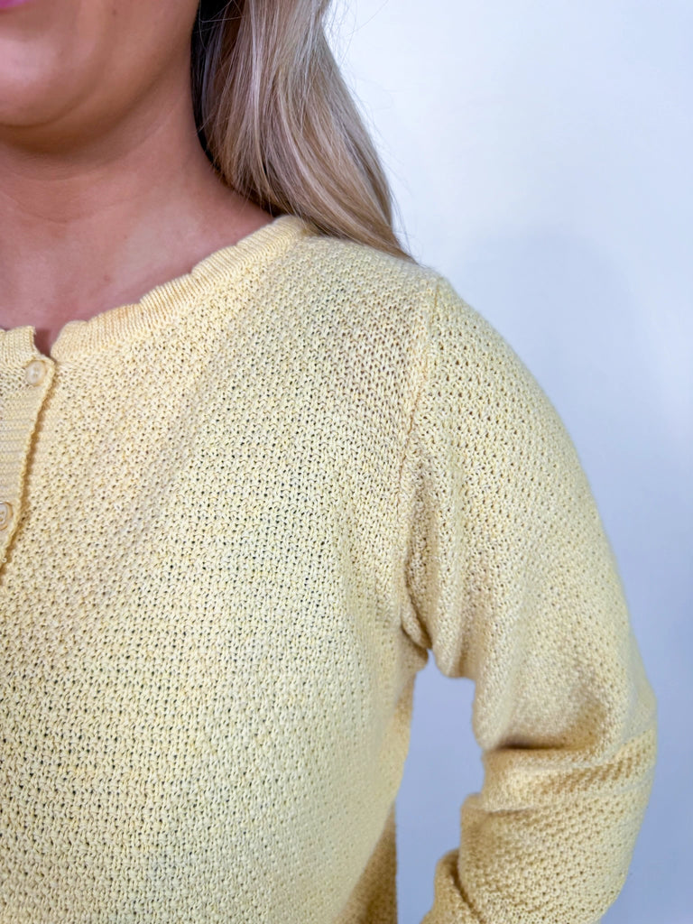 Woman wearing textured knit button-front cardigan in butter yellow and cornflower blue