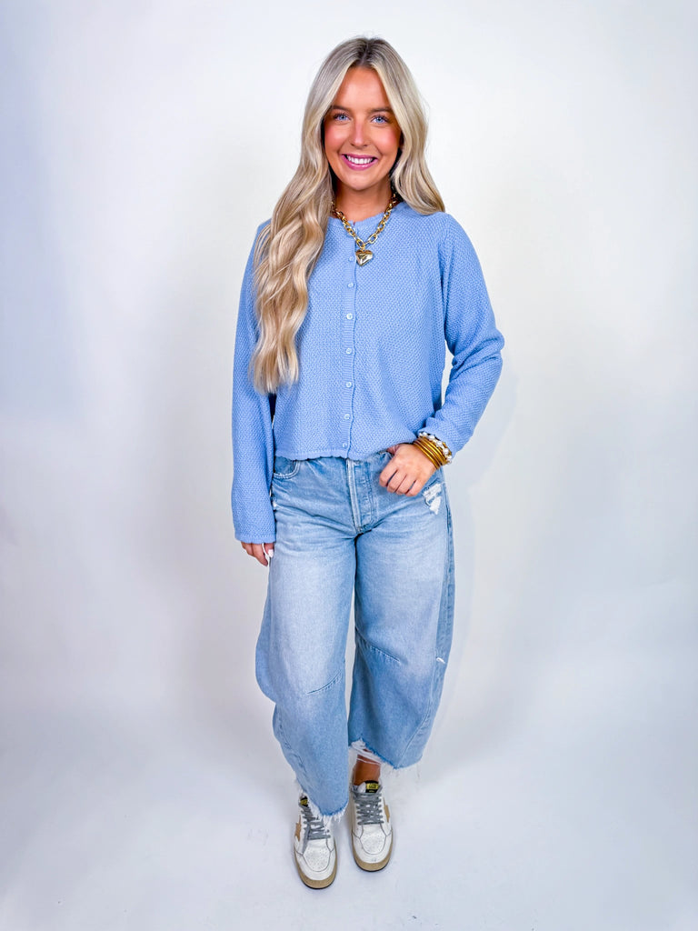 Woman wearing textured knit button-front cardigan in butter yellow and cornflower blue