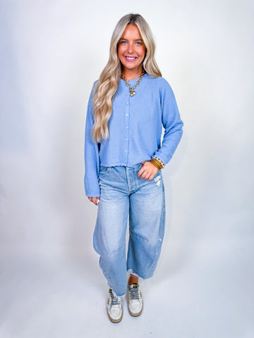 Woman wearing textured knit button-front cardigan in butter yellow and cornflower blue