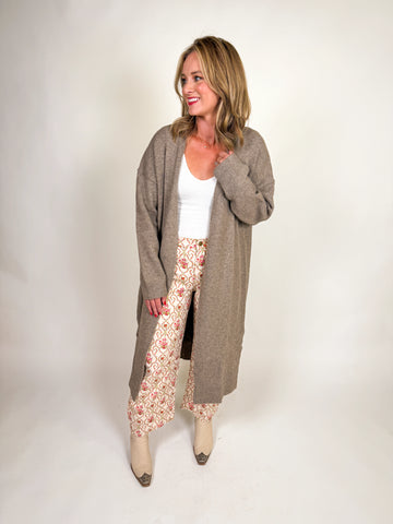 Woman wearing a longline taupe cardigan sweater with open front design