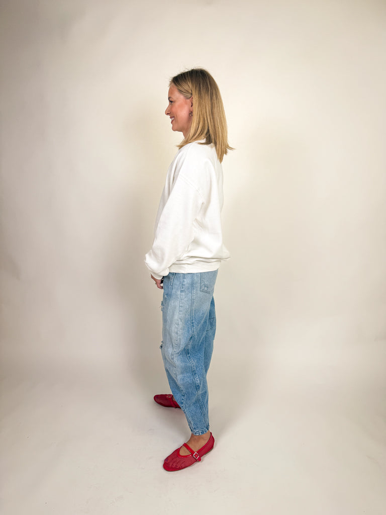 Woman wearing a white oversized sweatshirt with “i need a diet coke.