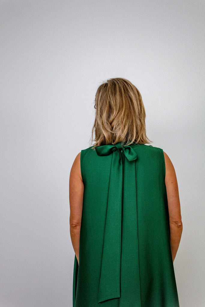 emerald green A-line gown with intricate floral embellishments and a high neckline