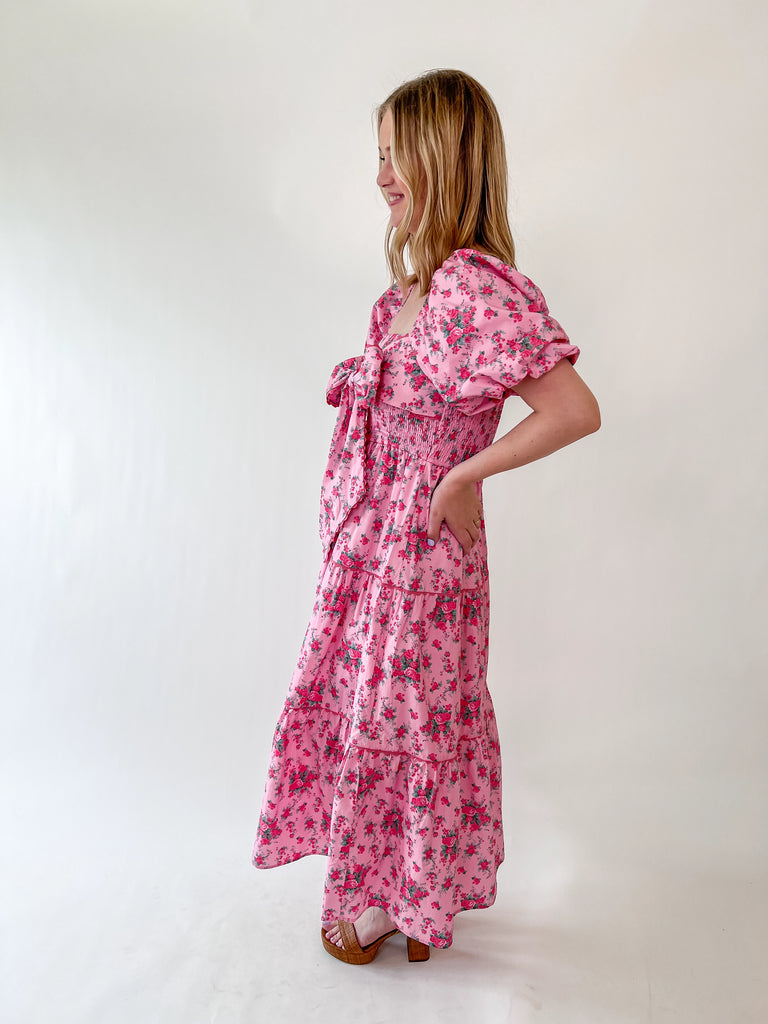 Pink floral dress with bow front, puff sleeves, and smocked top