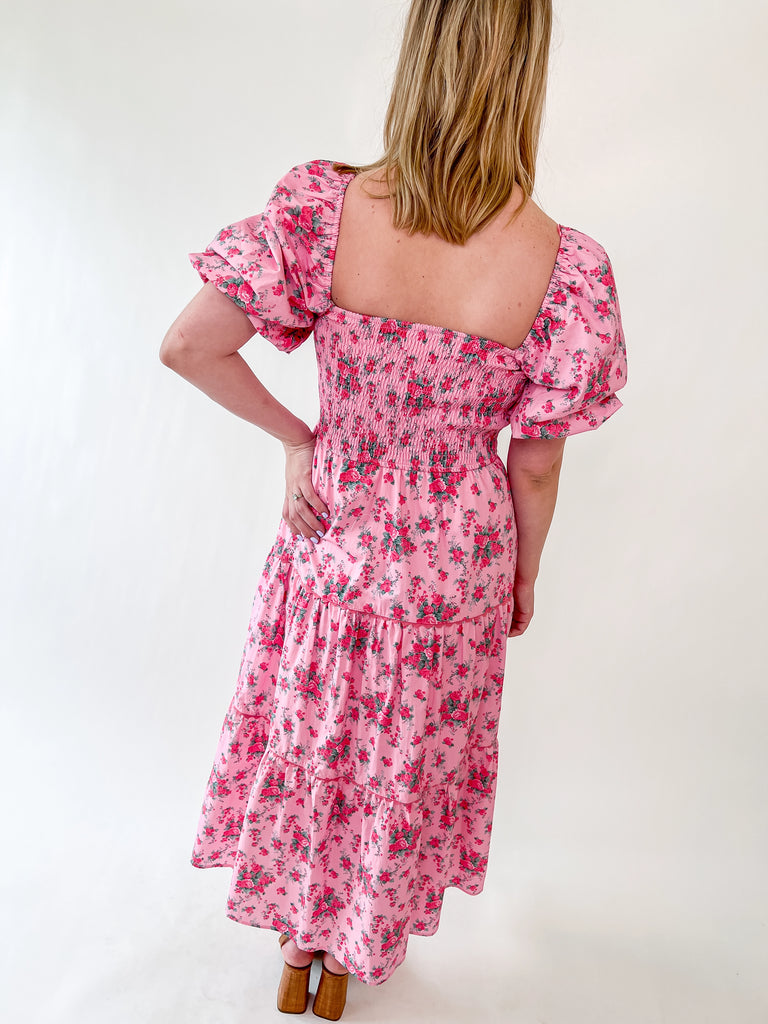 Pink floral dress with bow front, puff sleeves, and smocked top