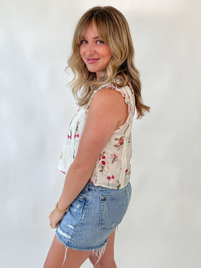 Sleeveless floral blouse with lace trim and ruffle shoulders