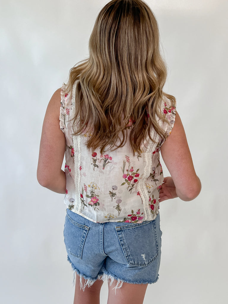 Sleeveless floral blouse with lace trim and ruffle shoulders