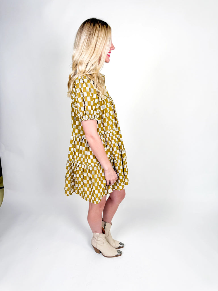 Golden Hour Check Dress in mustard and white check print with short sleeves, collared neckline, and tiered skirt