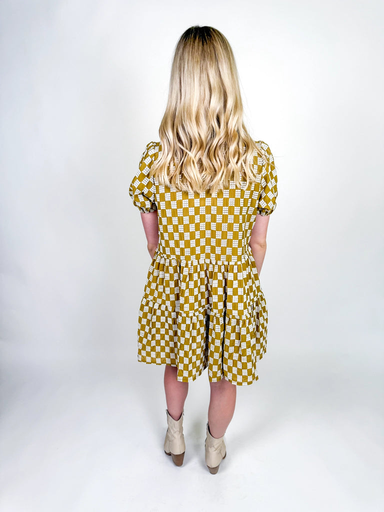 Golden Hour Check Dress in mustard and white check print with short sleeves, collared neckline, and tiered skirt