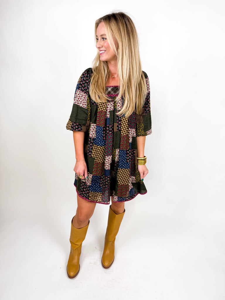 model wearing long sleeve patchwork babydoll dress in earthy floral tones