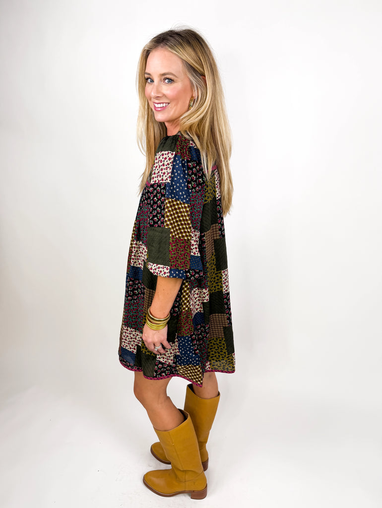 model wearing long sleeve patchwork babydoll dress in earthy floral tones