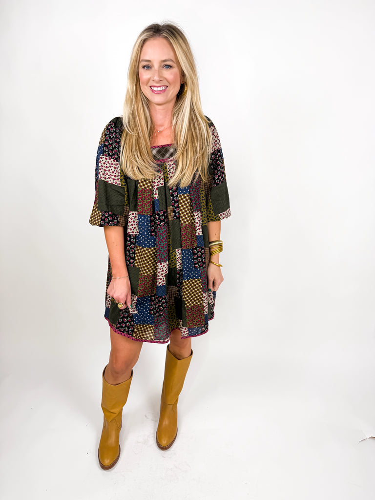 model wearing long sleeve patchwork babydoll dress in earthy floral tones