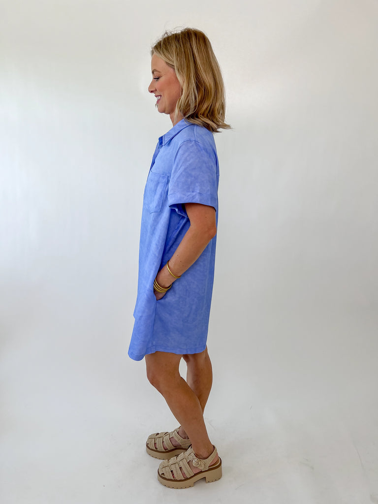 Woman wearing a casual blue polo dress with short cuffed sleeves and collar