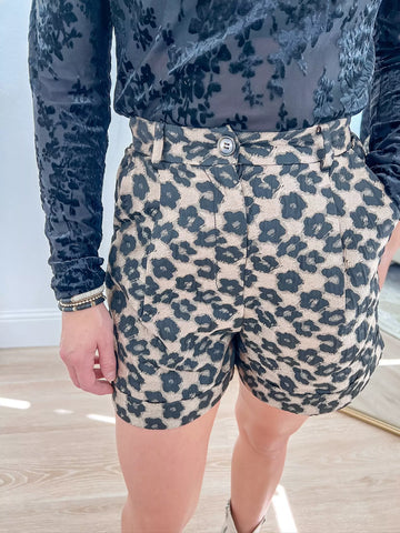 High-waisted leopard print shorts with a tailored fit, featuring belt loops, button closure, and pleats, perfect for bold and versatile looks, available now at our women’s boutique.