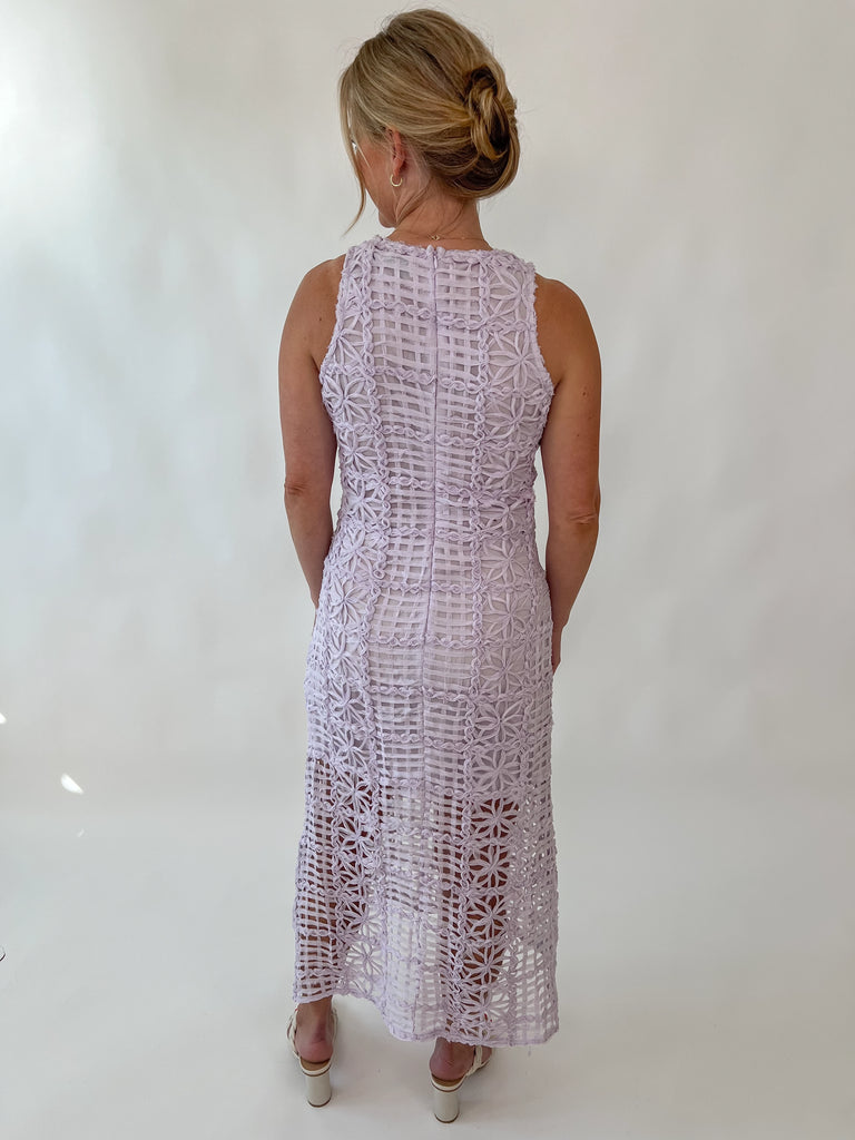 Model wearing sleeveless lavender lace midi dress with floral embroidery and sheer hemline