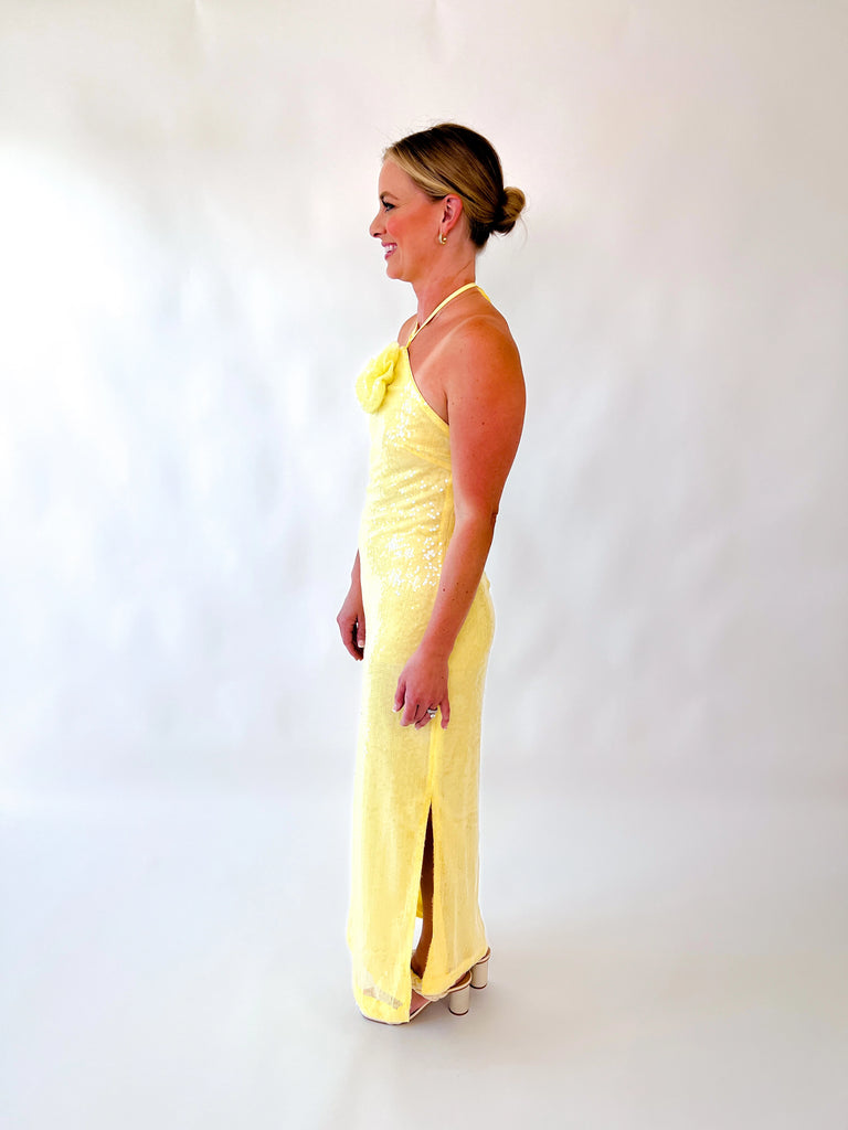 Woman wearing yellow halter sequin gown with floral detail