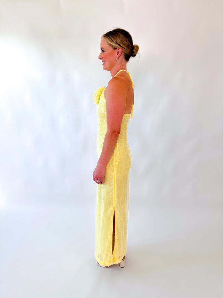 Woman wearing yellow halter sequin gown with floral detail