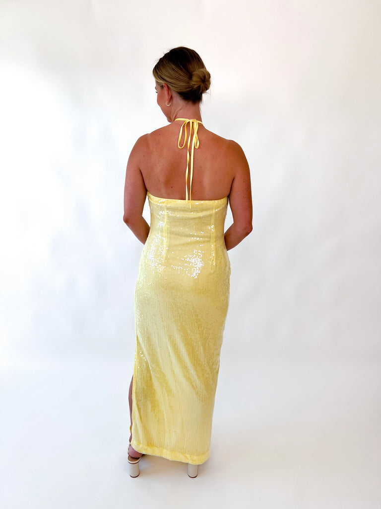 Woman wearing yellow halter sequin gown with floral detail