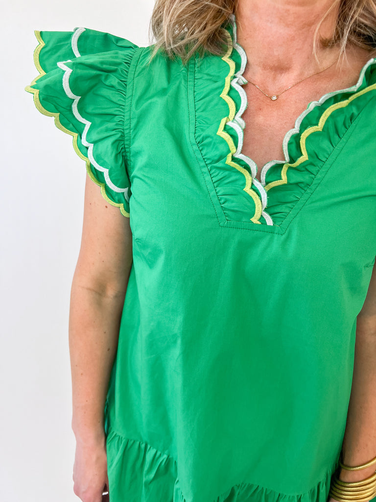 Green mini dress with scalloped flutter sleeves and v-notch neckline