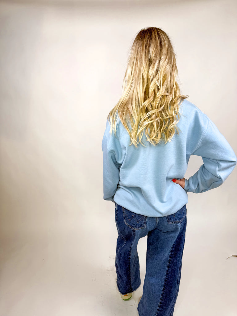model wearing light blue sweatshirt with red “Make America Pray Again” lettering