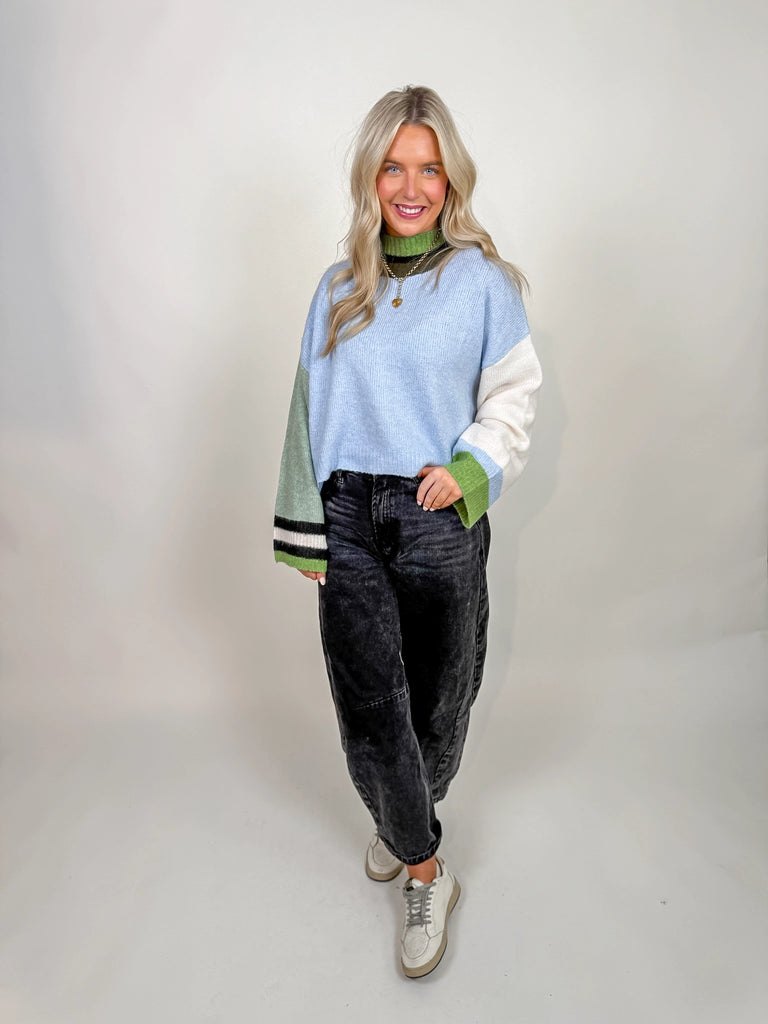 Woman wearing Morning Mist Sweater in color block design with green, blue, and cream tones