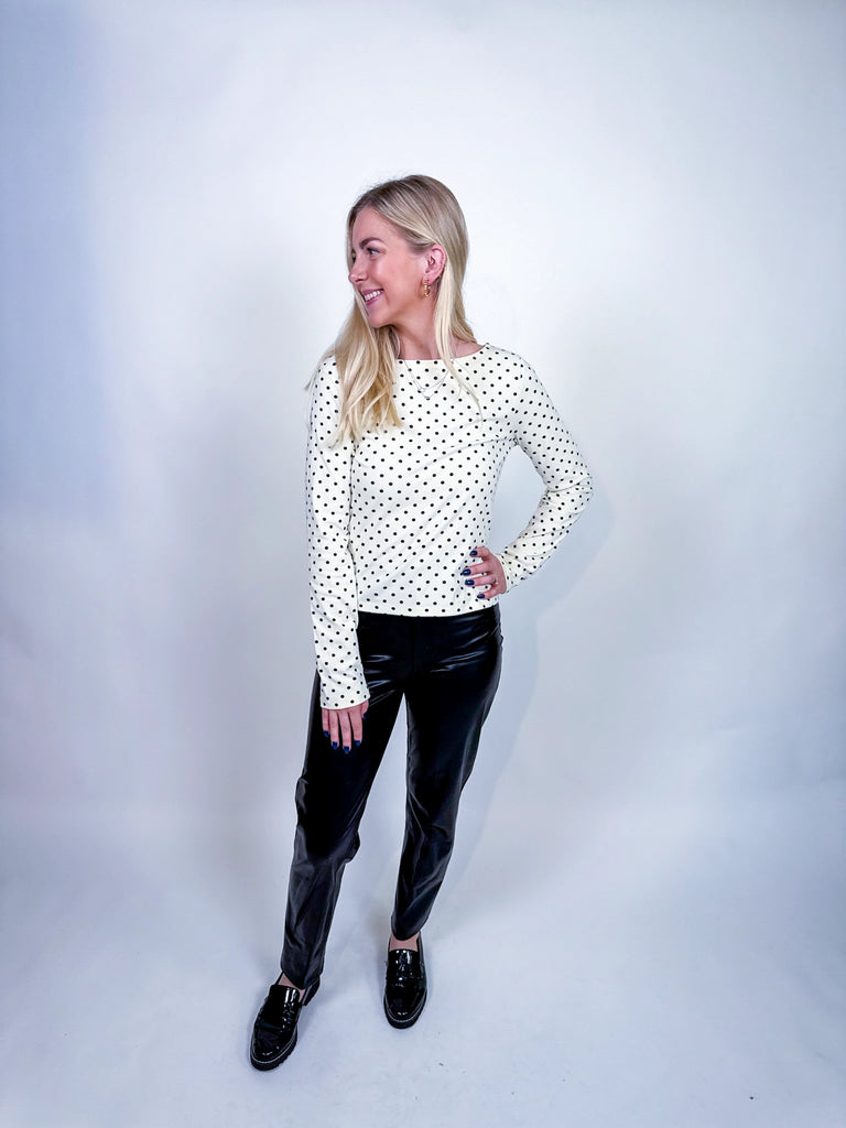 Woman wearing the On the Dot Top, a black-and-white polka dot long sleeve blouse.
