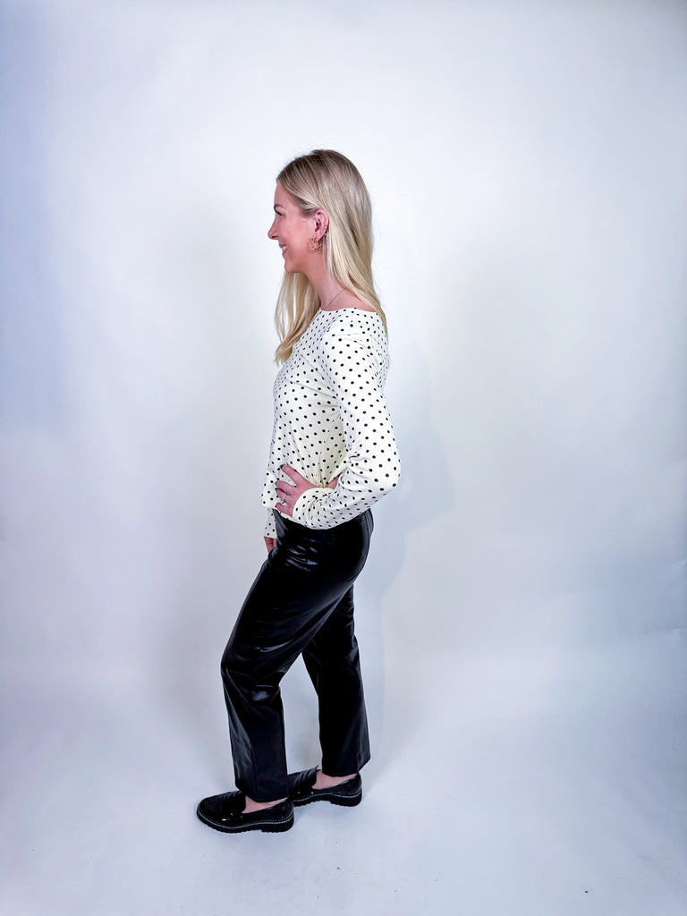 Woman wearing the On the Dot Top, a black-and-white polka dot long sleeve blouse.
