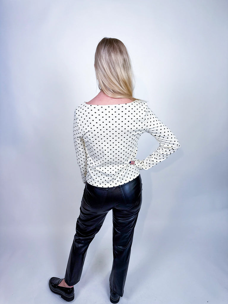 Woman wearing the On the Dot Top, a black-and-white polka dot long sleeve blouse.