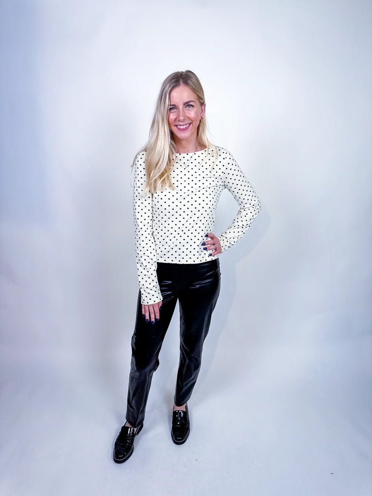Woman wearing the On the Dot Top, a black-and-white polka dot long sleeve blouse.