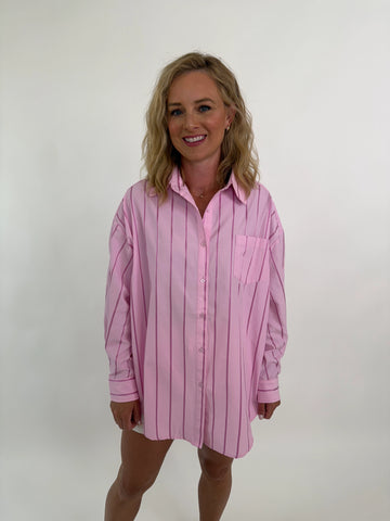 Woman wearing oversized pink striped shirt dress