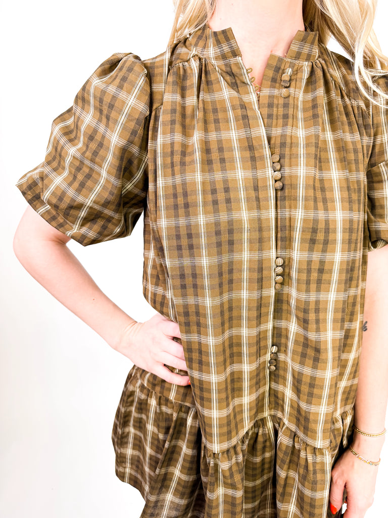 model wearing brown plaid mini dress with puff sleeves and button-front detail