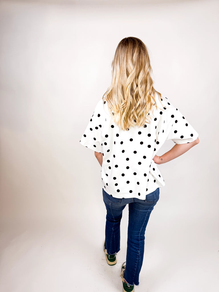 model wearing white tee with black polka dots
