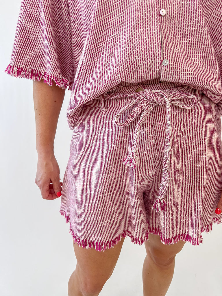 Woman wearing red and white drawstring fringe shorts