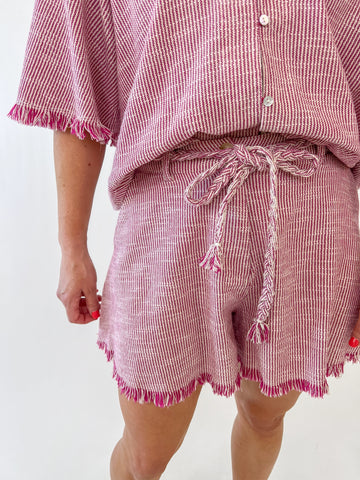 Woman wearing red and white drawstring fringe shorts