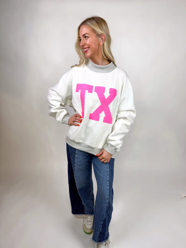 model wearing reversible texas sweatshirt with pink TX and gray TEXAS sides